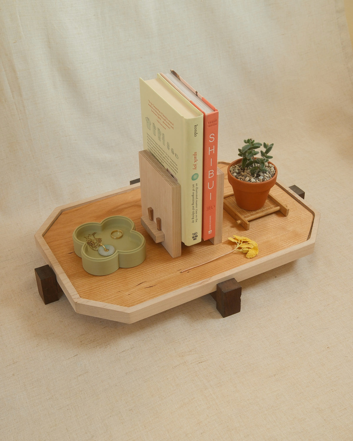 A long Zen Tray with books, a book stand and a plant on linen