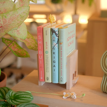 A Zen Book Stand holding books between the plants