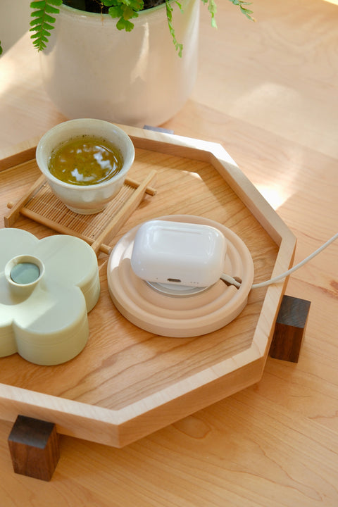 Zen MagSafe Charger Puck in Dusty Blush charging AirPods on the maple Zen Tray, with a cup of tea and a Pistachio Fa Trinket Tray