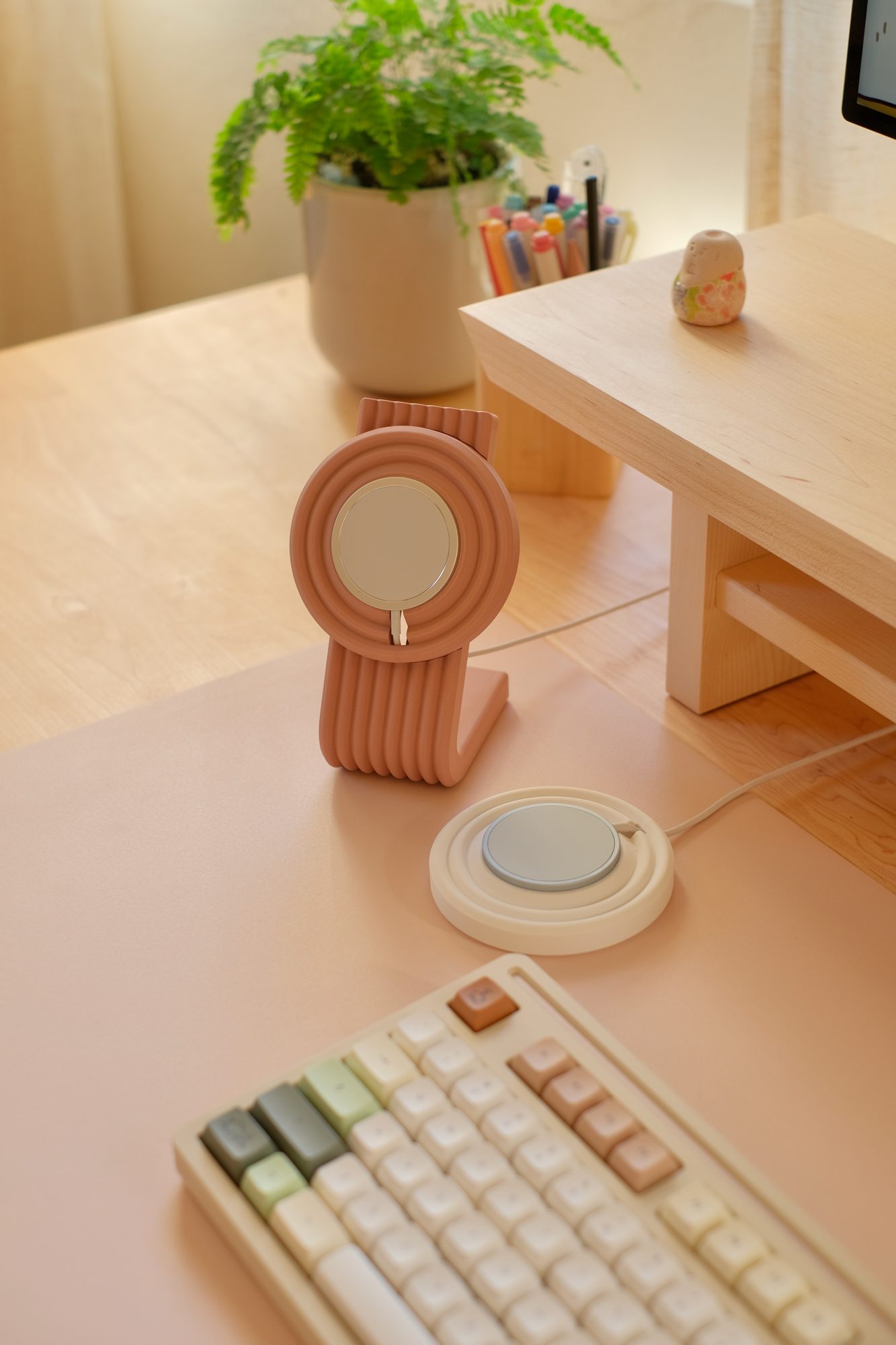 A Rose Zen MagSafe Charger Stand and a White Zen MagSafe Charger Puck on a Blush Cozyleigh Desk Mat
