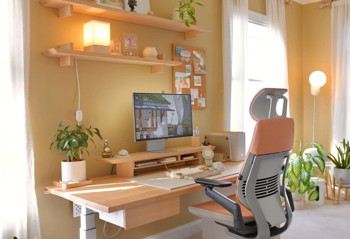 A cozy desk setup with a Cozyleigh desk mat, Zen MagSafe charger stand and warm lighting