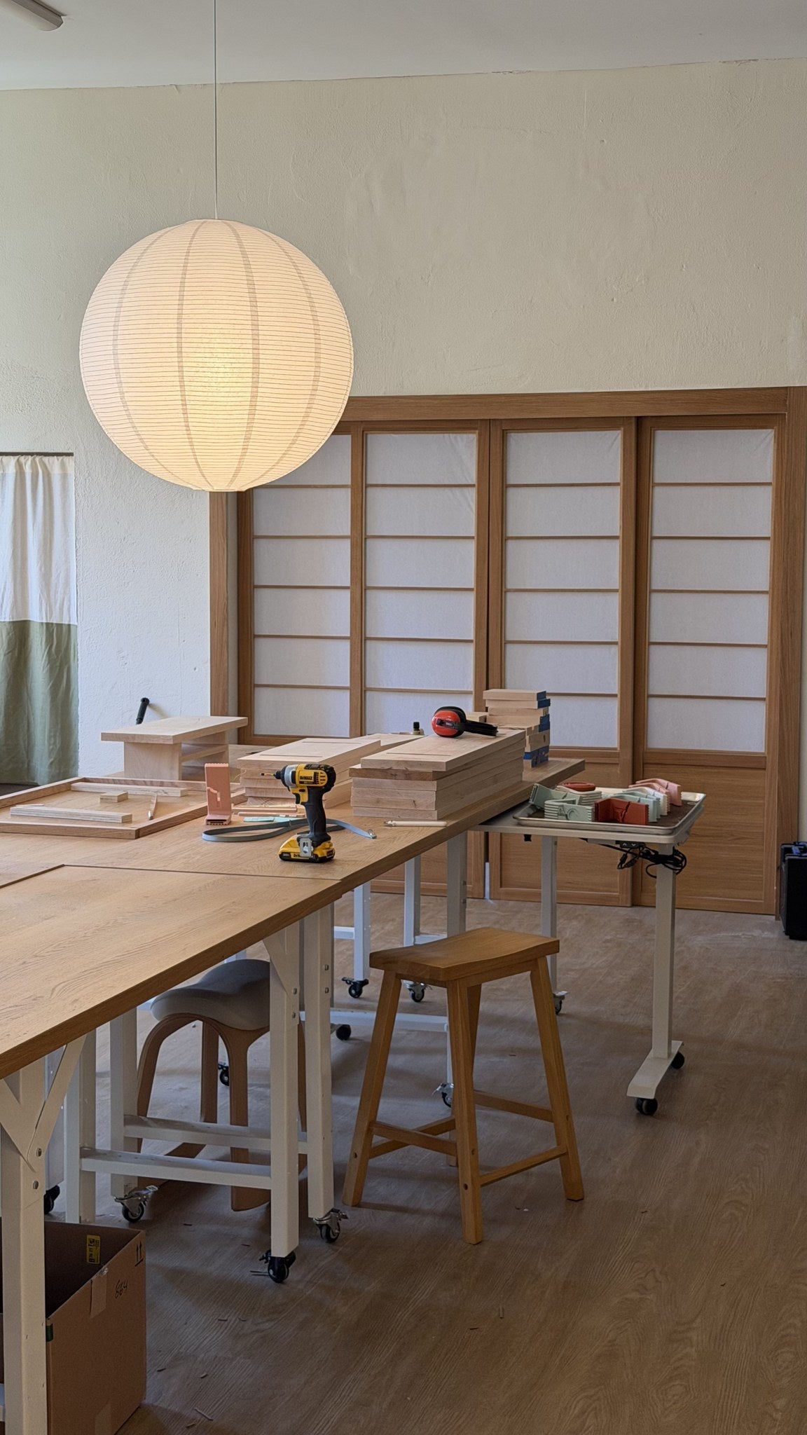 A batch of wooden desk shelves laid out on a long table