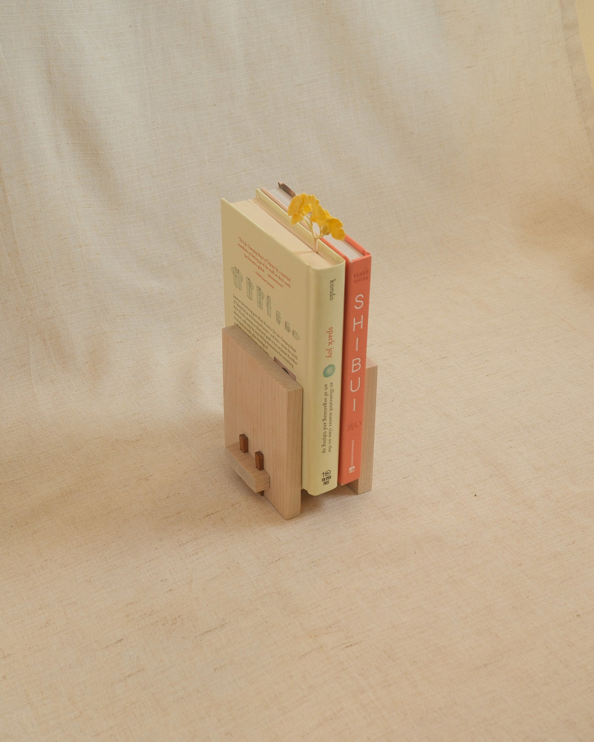 A Zen Book Stand holding books on linen