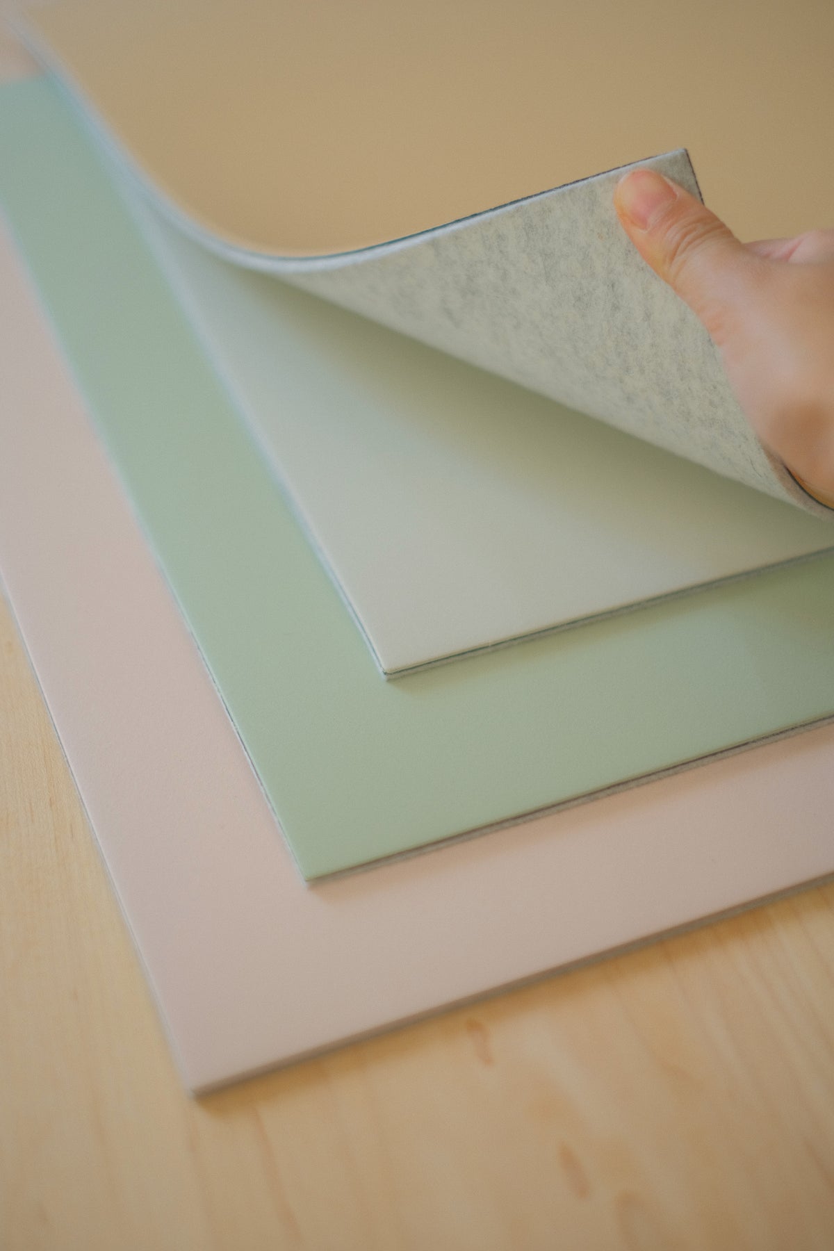 Peeling back a desk mat corner to show both sides