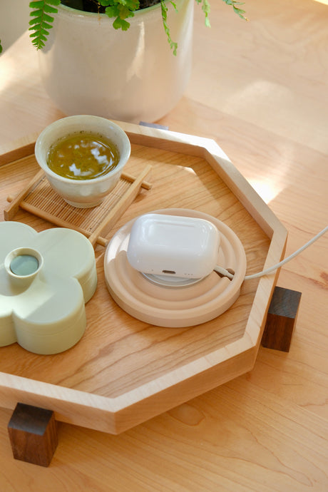 Zen MagSafe Charger Puck in Dusty Blush charging AirPods on the maple Zen Tray, with a cup of tea and a Pistachio Fa Trinket Tray