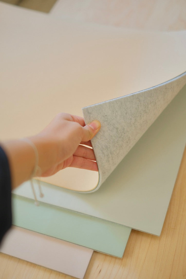 Peeling back a desk mat to show the merino side