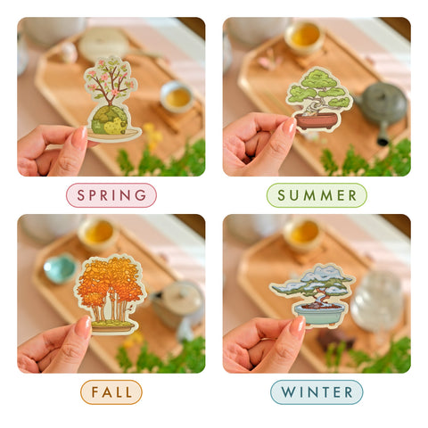 The four bonsai stickers held up one by one over a tea tray, each labelled: spring in pink, summer in green, fall in orange and winter in blue
