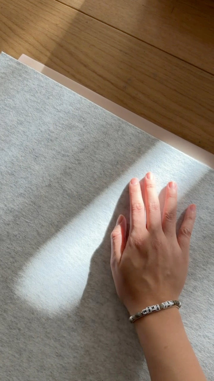 A hand on the soft merino side of a desk mat