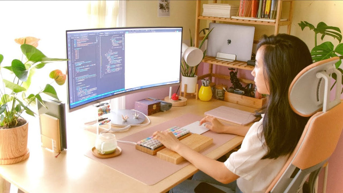 Maisy at her work-from-home desk in October 2020, coding on a wide monitor