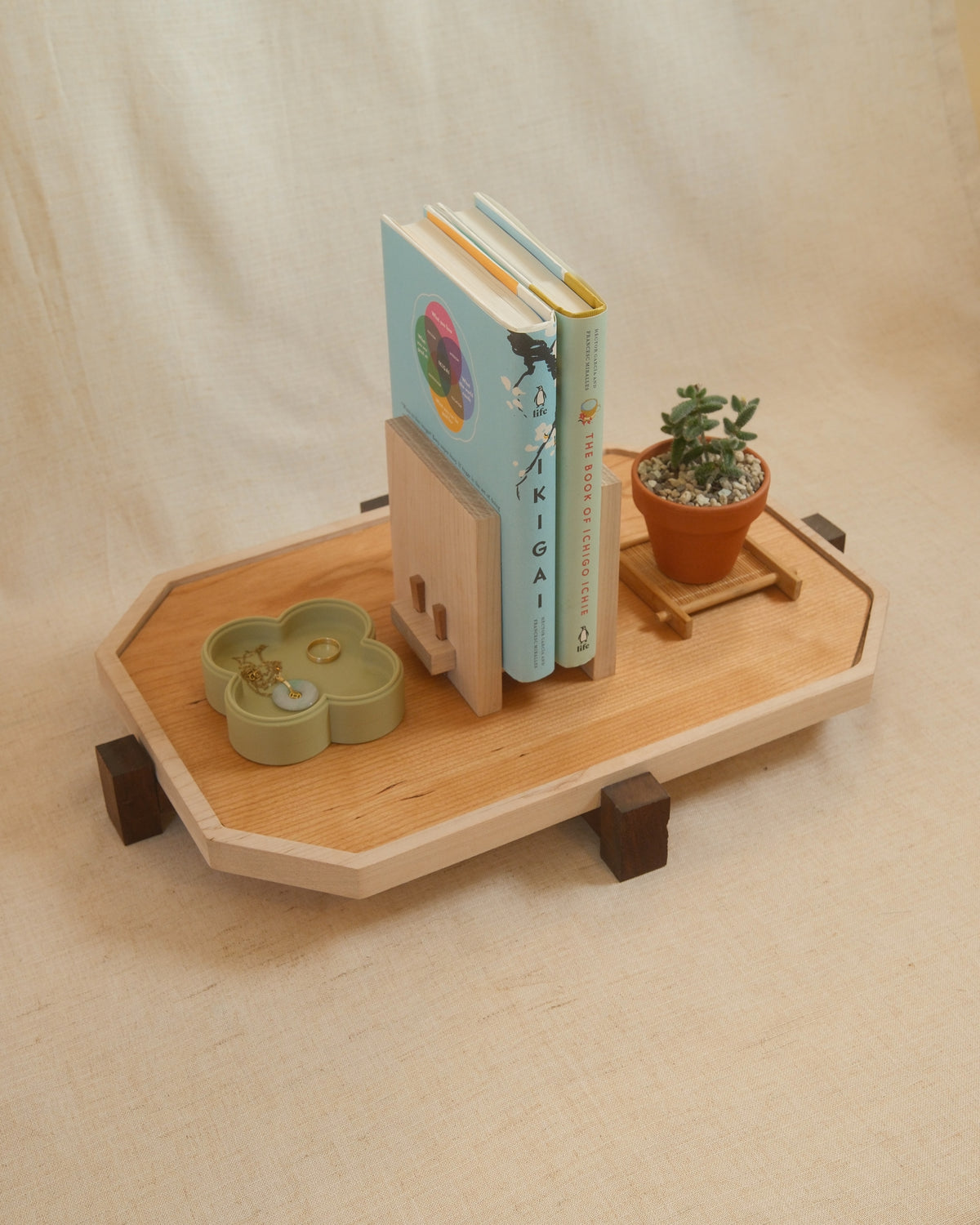 A long Zen Tray with books, a book stand and a plant on linen