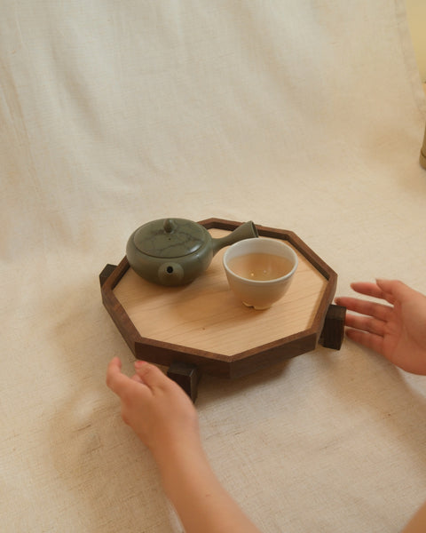 Carrying the Zen Tray in Maple, Medium, with a tea set: the tray in two hands for scale